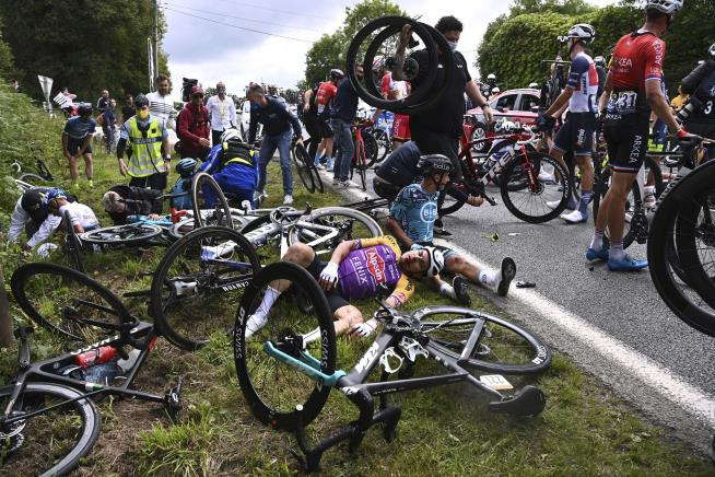 Bicyclists rest on the ground after a massive crash