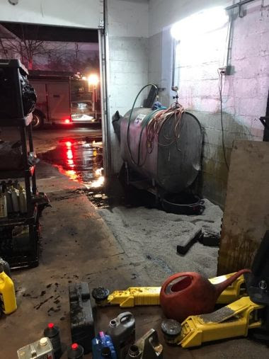 View from inside auto shop where oil take is leaking all over the floor