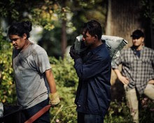 Image of two males greenskeepers covered in dirt working. One male with clean clothes supervising.