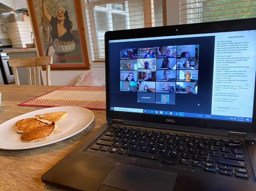 A laptop on a kitchen table, showing a virtual meeting for the phonebank event.