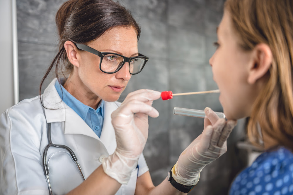 female doctor performing throat swab for female patient