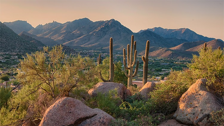 The figure shows Pinnacle Peak Park in Scottsdale, Arizona as the sun rises over cactus and hiking trails.