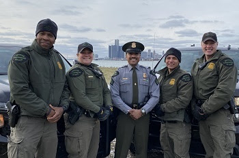 group of conservation officers with Detroit skyline in background