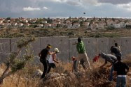 Palestinians hurl stones onto the Israeli side of the separation barrier