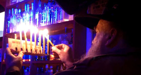 Orthodox Jew
                lights hanukkiah (Hanukkah menorah) in Jerusalem pub.
                (YouTube capture)