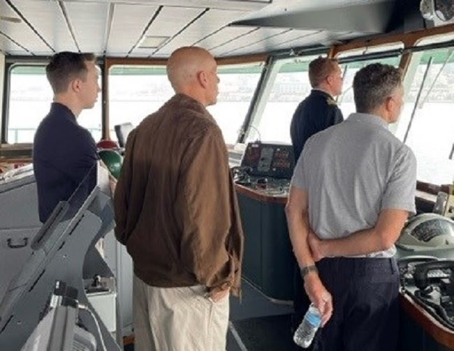 Four people in the pilothouse of a ferry