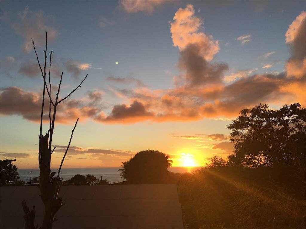 沈む夕日の空に満月が浮かんでいる。