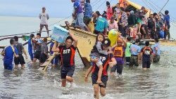 Alcune persone che cercano di mettersi in salvo dopo il passaggio del tifone Megi nelle Filippine.