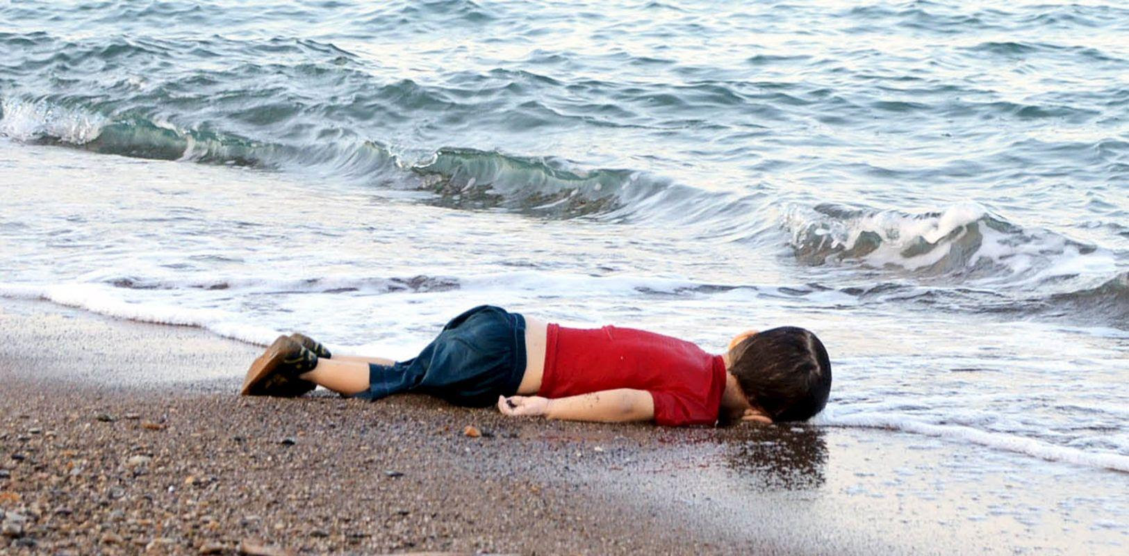 A young migrant, who drowned in a failed attempt to sail to the Greek island of Kos, lies on the shore in the Turkish coastal town of Bodrum