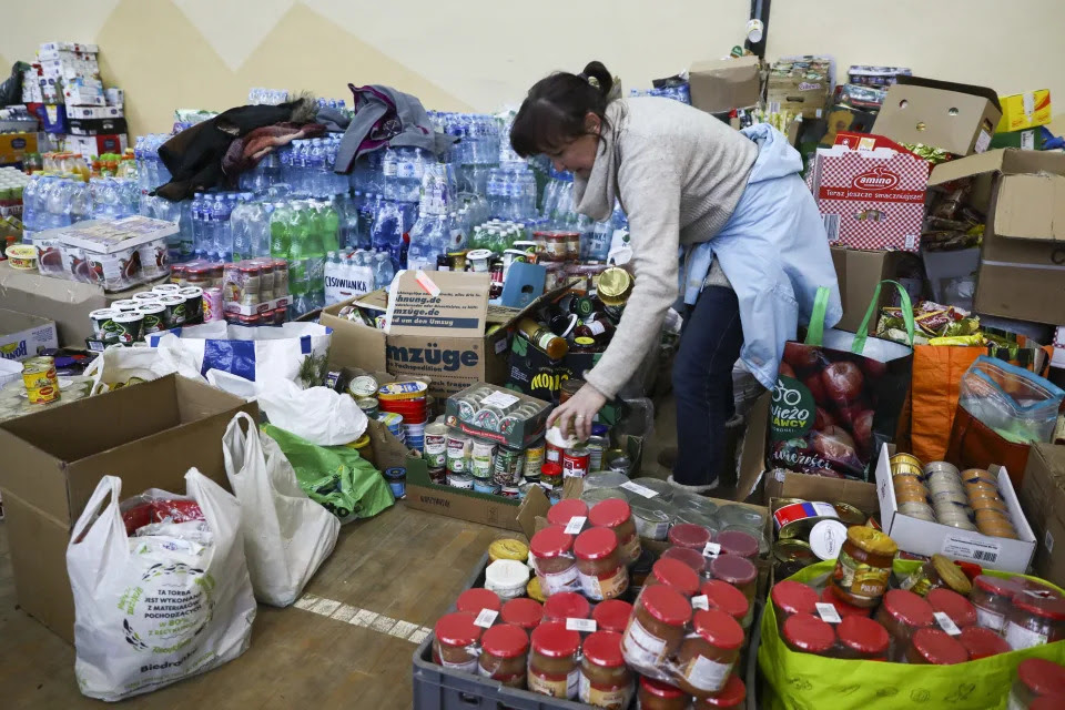 A volunteer unloads aid donations at a school gym in Poland.