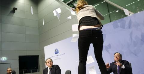 Una joven se sube a la mesa donde estaba Mario Draghi. /REUTERS