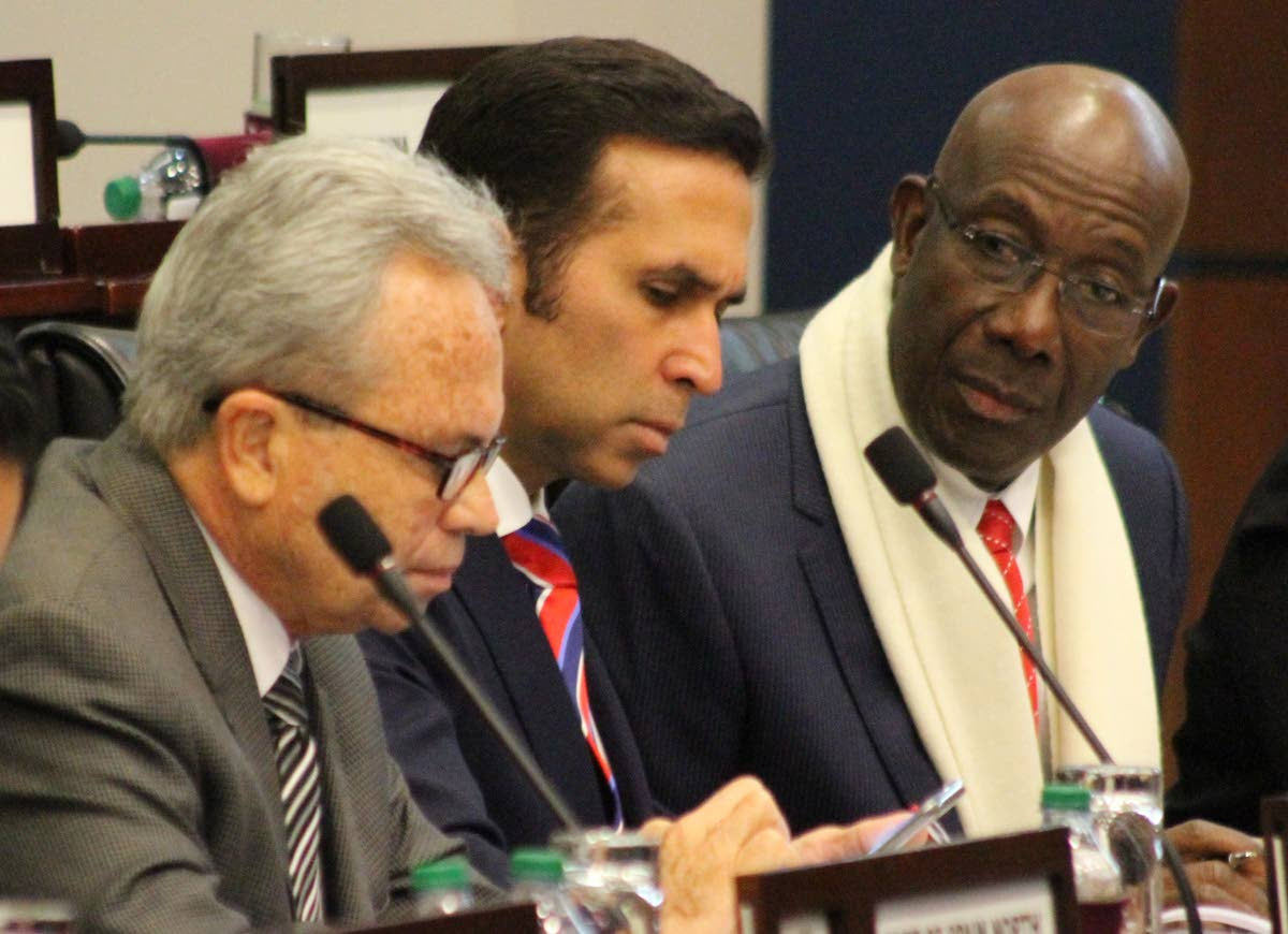 PUTTING HEADS TOGETHER: Prime Minister chats with Attorney General Faris Al-Rawi and Finance Minister Colm Imbert during yesterday’s sitting of the House of Representatives yesterday.