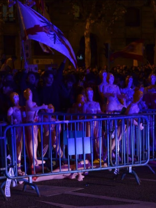 a crowd of people standing behind a barricade at a parade