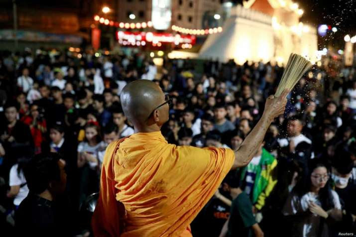 A buddhist monk sprinkles holy water on Sunday as people pray for victims of the mass shooting in Nakhon Ratchasima, Thailand. From voanews.com