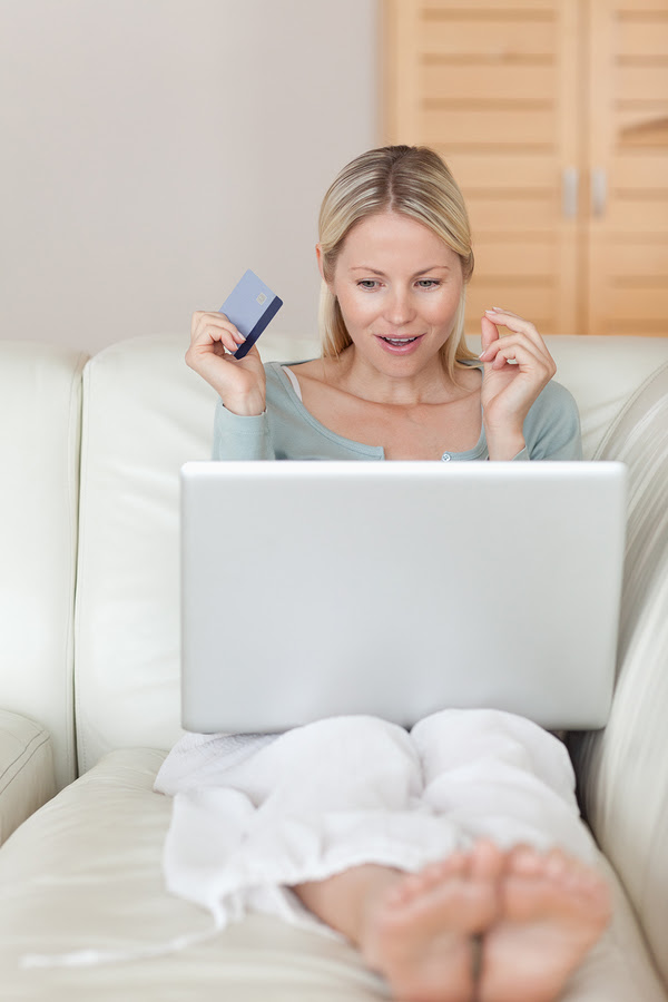 Young woman on the sofa about to win an online auction
