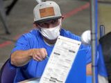 Maricopa County ballots cast in the 2020 general election are examined and recounted by contractors working for Florida-based company, Cyber Ninjas, Thursday, May 6, 2021 at Veterans Memorial Coliseum in Phoenix. The audit, ordered by the Arizona Senate, has the U.S. Department of Justice saying it is concerned about ballot security and potential voter intimidation arising from the unprecedented private recount of the 2020 presidential election results. (AP Photo/Matt York, Pool) **FILE**