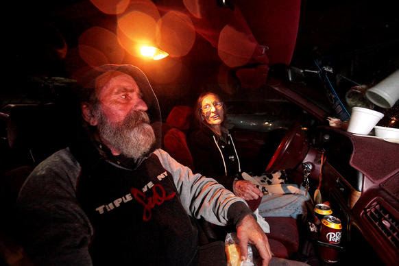 Siblings Addison Dorsten, 59, left, and Christine Chapman, 65, right, eat dinner in their car at the Sonoma County "Safe Parking" lot at the fairgrounds in Santa Rosa.
