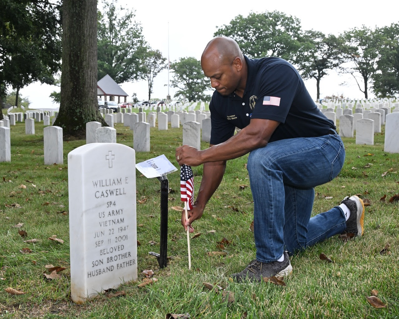 Governor Wes Moore kneeling at grave of William E. Caswell