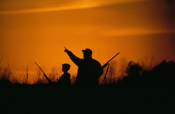 boy and father waterfowl hunting at sunset
