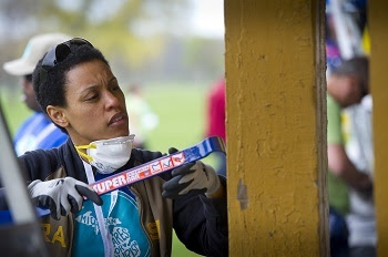 A volunteer scrapes old paint off a picnic shelter at Belle Isle Park in Detroit