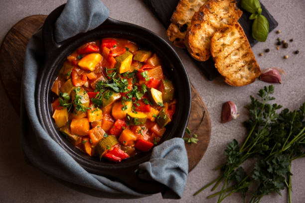 Cooked various chopped vegetables with herbs in a black cooking pot Cooked various vegetables with herbs in a black cooking pot ratatouille stock pictures, royalty-free photos & images