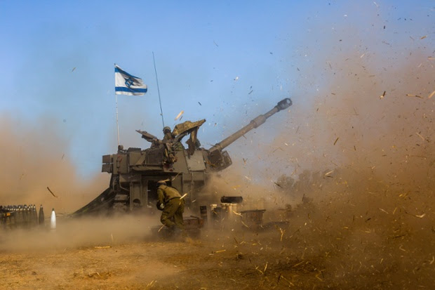 Israeli soldiers use a self-propelled howitzer fire a shell towards Gaza at a position in Southern Israel.