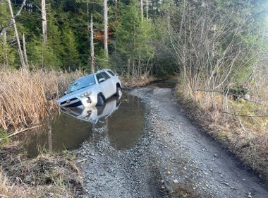 SUV stuck in water on unmaintained road