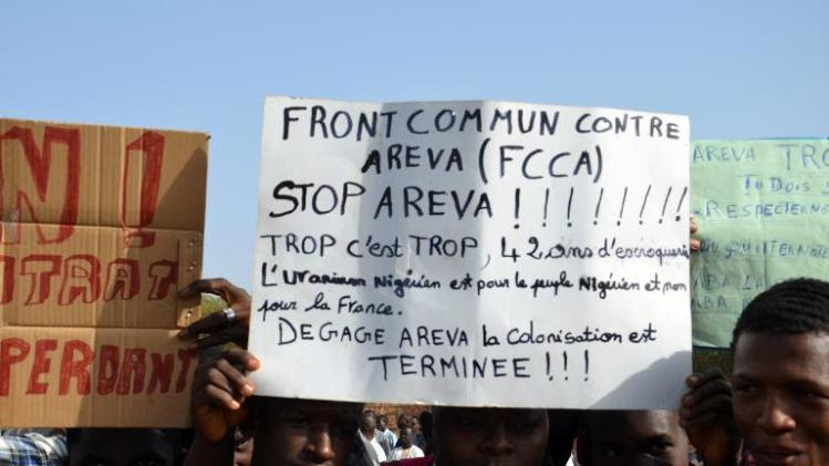 A protester holds an anti-Areva banner at a demonstration in Niamey on December 21, 2013