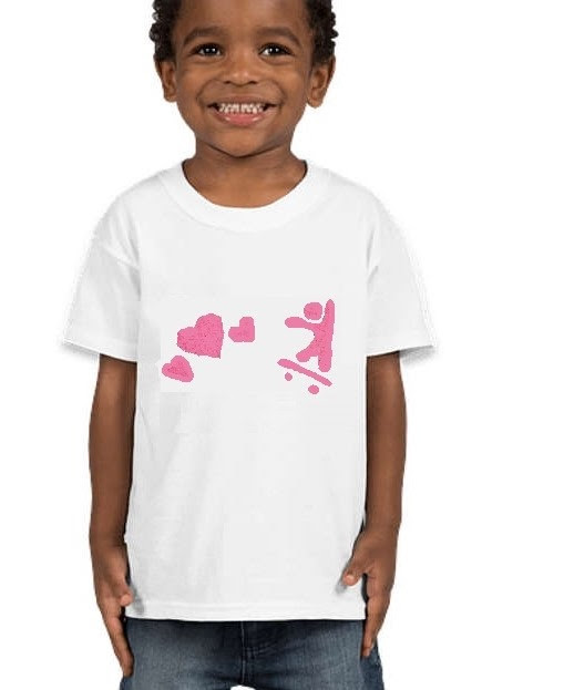 A smiling kid wears a Tshirt with a skateboarder and hearts stenciled onto it.