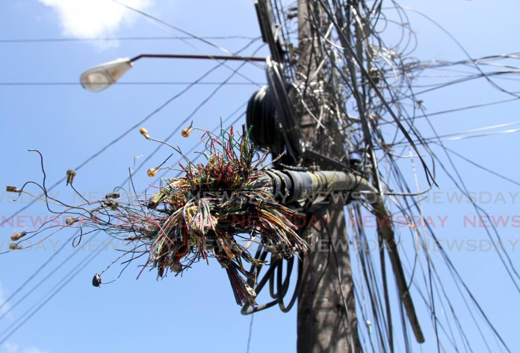 Cut cable lines hang from a line on Corinth Street in San Fernando on Wednesday. TSTT says 161 people have been taken to court by police for offences related to stealing copper from its utility lines. Photo by Ayanna Kinsale