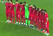 Turkish and Greece soccer players stand in silent while fans boo and shout 