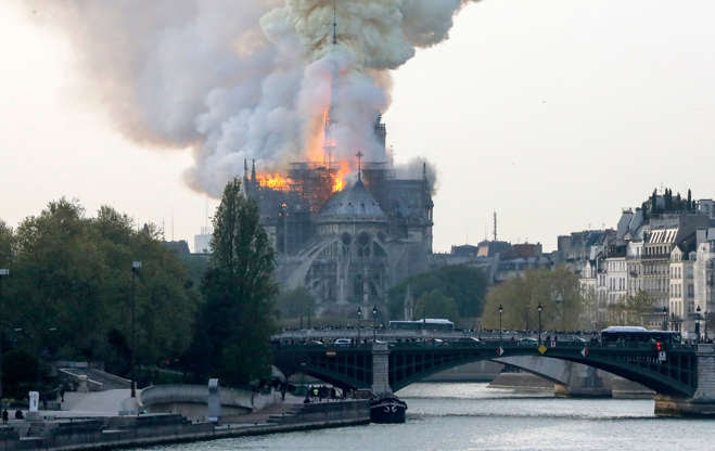 Slide 30 of 31: TOPSHOT - Smokes ascends as flames rise during a fire at the landmark Notre-Dame Cathedral in central Paris on April 15, 2019 afternoon, potentially involving renovation works being carried out at the site, the fire service said. (Photo by FRANCOIS GUILLOT / AFP)        (Photo credit should read FRANCOIS GUILLOT/AFP/Getty Images)