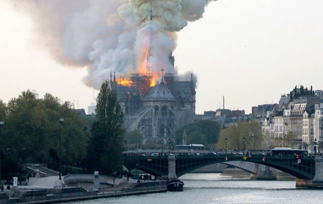 Slide 30 of 31: TOPSHOT - Smokes ascends as flames rise during a fire at the landmark Notre-Dame Cathedral in central Paris on April 15, 2019 afternoon, potentially involving renovation works being carried out at the site, the fire service said. (Photo by FRANCOIS GUILLOT / AFP) (Photo credit should read FRANCOIS GUILLOT/AFP/Getty Images)