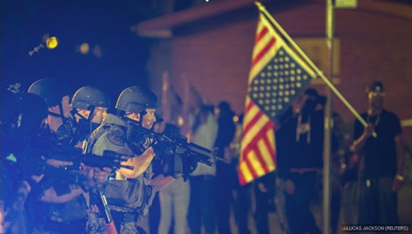  - Lucas Jackson (REUTERS) Un oficial de Policía apunta su arma contra los manifestantes. Los disturbios durante la noche han dejado 31 detenidos.