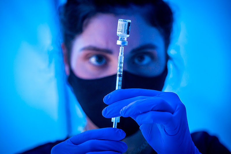 A medical student loads a syringe with Pfizer COVID-19 vaccine in Los Angeles.