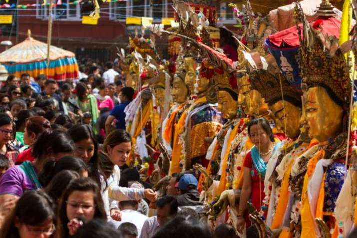 Devotees offer alms to the keepers of Buddhist deities. From kathmandupost.com