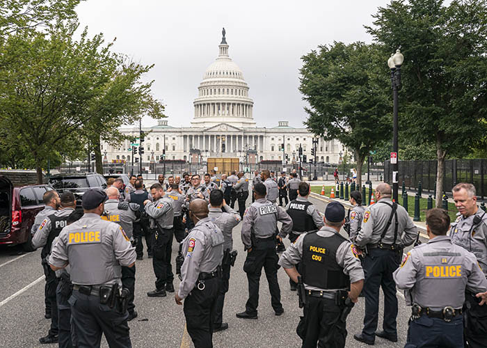 Police stage at a security fence ahead of a rally near the U.S. Capitol in Washington, Saturday, Sept. 18
