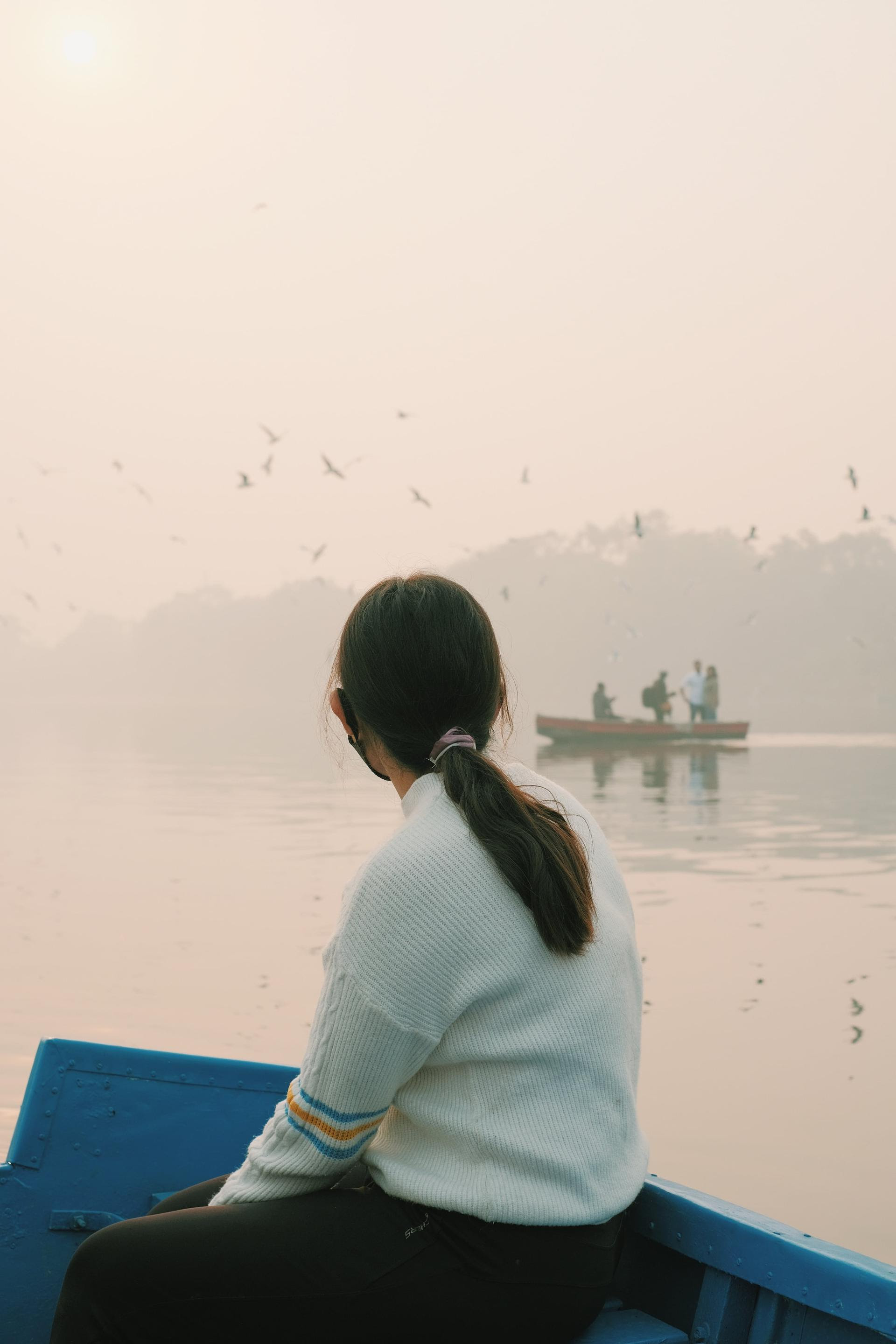 Femme regardant la mer avec un bateau au loin