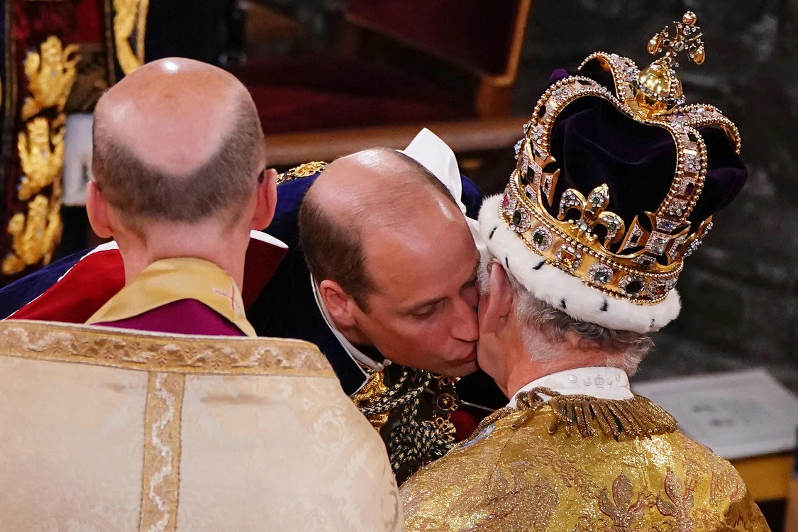 Hoàng tử William hôn cha mình, Vua Charles III, trong lễ đăng quang.  (Ảnh Yui Mok/POOL/AFP)