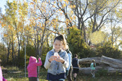 Girl with a bug jar outside in fall