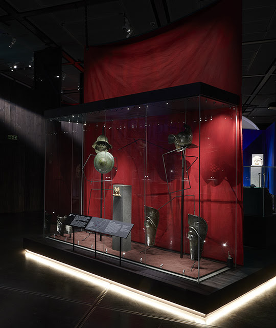Inside 'Nero: the man behind the myth' showing gladiators' armour and helmets on display against a red background.