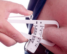 Person having their body fat measured near their waist with a caliper. 