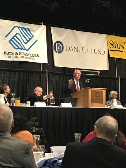 Peter Wold speaks from a podium on the stage at the Boys and Girls Club of Central Wyoming's Back-a-Kid Breakfast in the Casper Events Center.