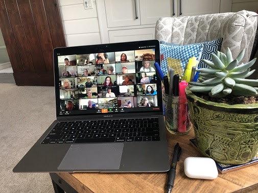 A laptop showing a phonebanking Zoom meeting sits on an end table.