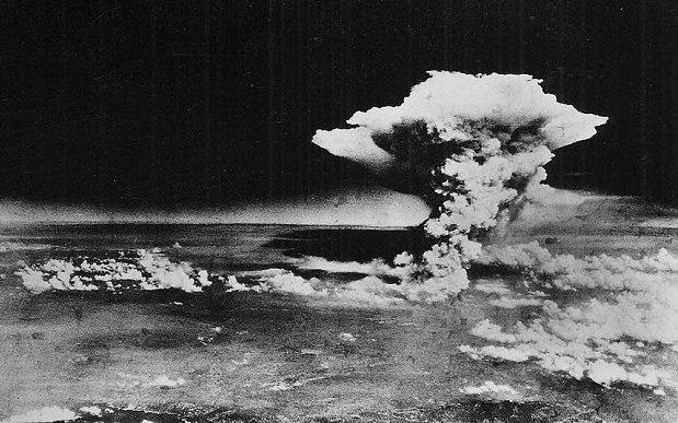 An atomic cloud billows above Hiroshima city following the explosion of the first atomic bomb to be used in warfare in Hiroshima on August 6, 1945
