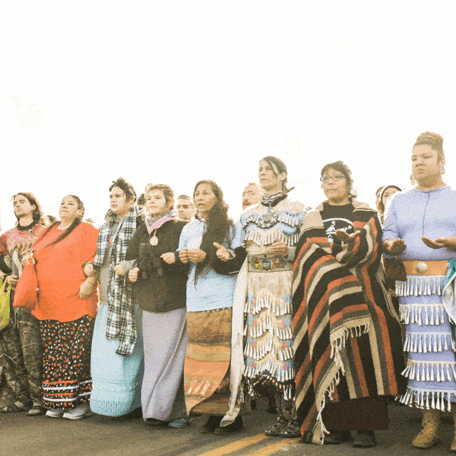 GIF of Indigenous women standing together with the phrase "we are power" written across