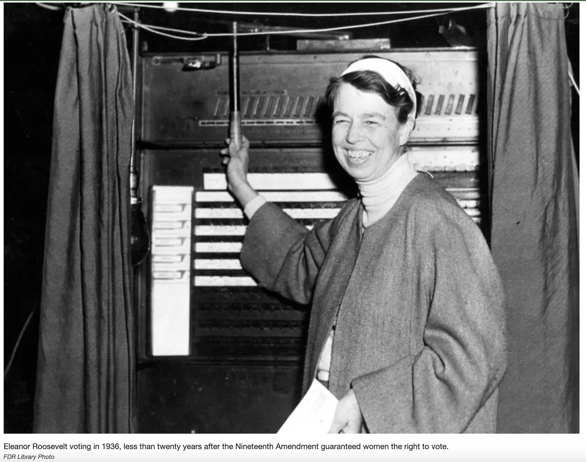 Eleanor Roosevelt standing in front of a voting booth in 1936