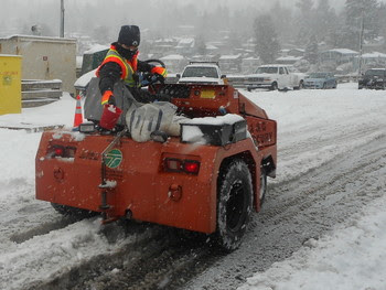 Photo of person salting the road surface at Fauntleroy terminal while riding a bull vehicle