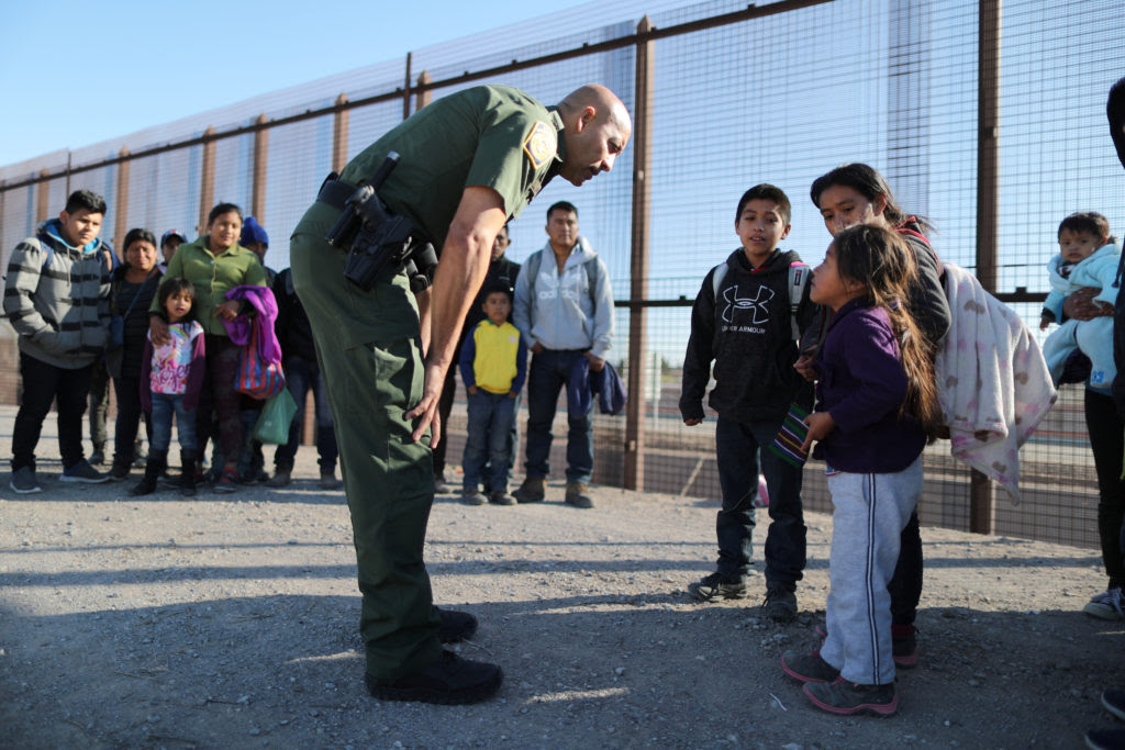 Border patrol agent talking with immigrant families
