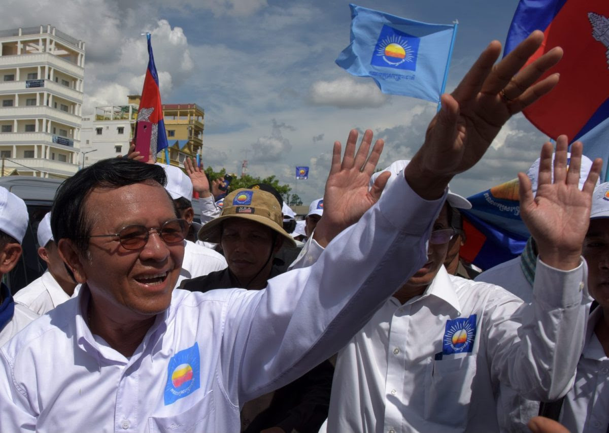 Kem Sokha (L), leader of Cambodia National Rescue Party (CNRP) greets supporters in a rally on the last day of the commune election campaign in Phnom Penh on June 2, 2017.A sea of pro-government supporters rallied in the Cambodian capital in support of strongman PM Hun Sen on June 2, two days before local polls set to test the mettle of an opposition desperate to upend his 32-year rule. / AFP PHOTO / TANG CHHIN SOTHY